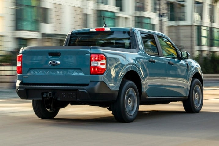 A Ford Maverick XLT drives on a city street, rear view of the truck