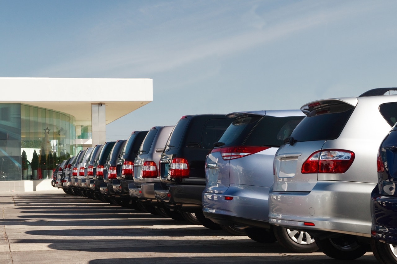 Vehicles on a dealership lot lined up in a row