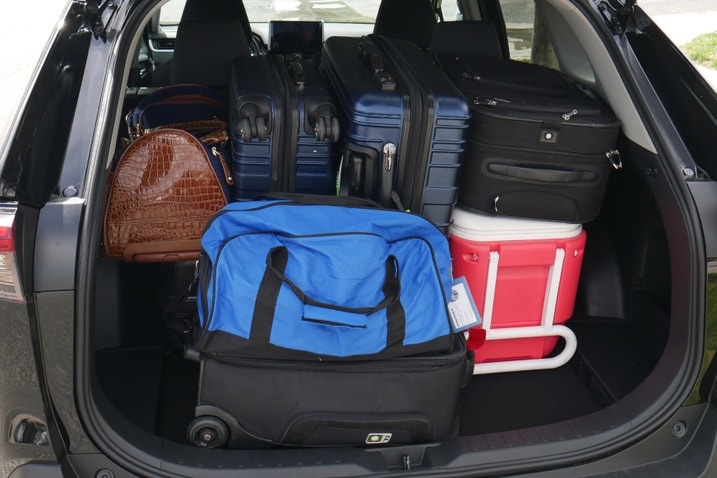 Seven suitcases and a cooler in a Toyota RAV4 cargo area