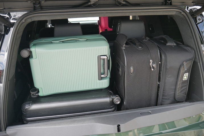 Rivian R1S cargo area behind third row with four suitcases