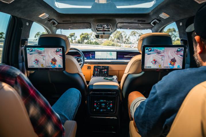Two passengers playing Mario Kart World on the 2026 Escalade IQL's rear entertainment displays
